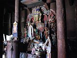 Mustang Lo Manthang 04 03 Jampa Gompa Main Floor Large Statue Of Jampa Maitreya The central feature of the three-story Jampa Lhakhang in Lo Manthang is an enormous 15m gilded clay statue of an enthroned Jampa (Maitreya), the Future Buddha. In the light from the open door, the huge golden figure glows softly. The body and crowned head of the statue rise into the lhakhang, the second or middle floor, where they are covered with a full ceiling overhead. The base of Jampa's throne is set into a smaller room at the level of the courtyard. The paintings on this first floor are being restored as of 2008.